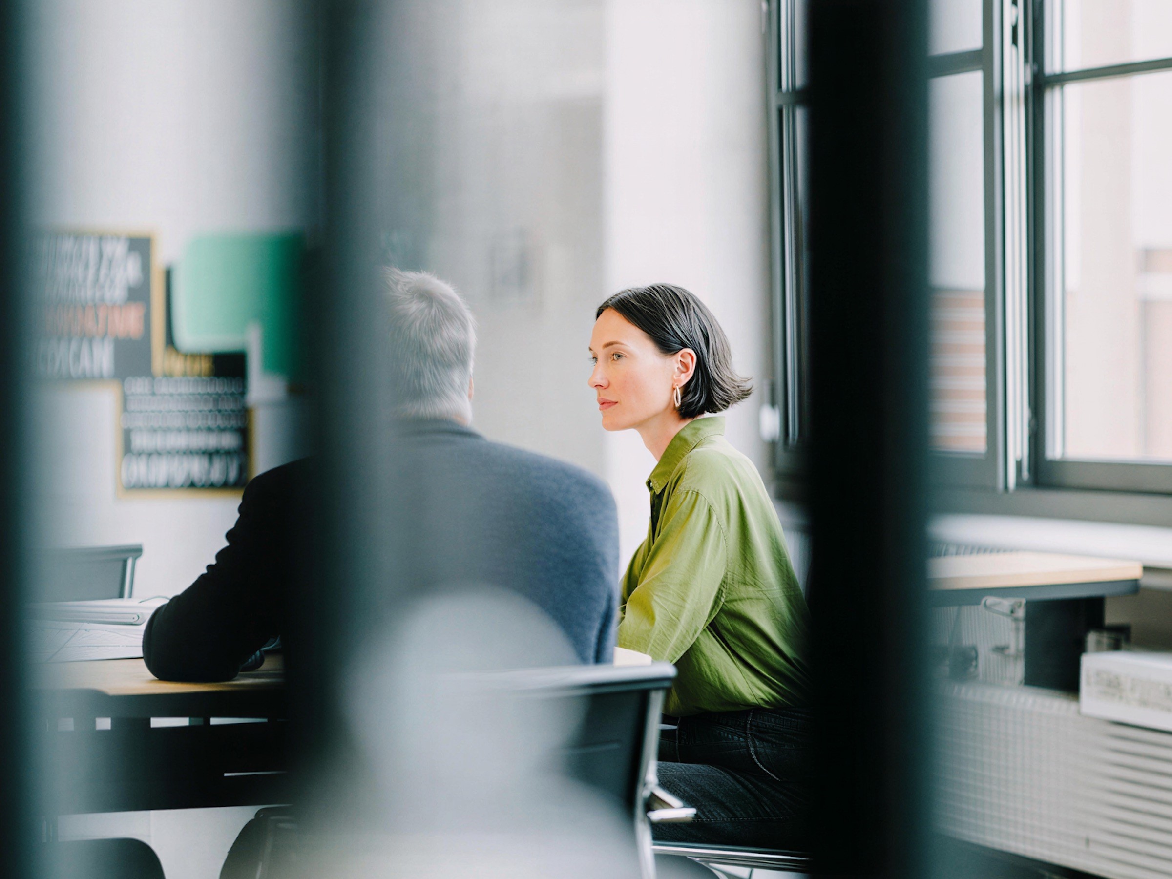A woman in a green shirt in a meeting